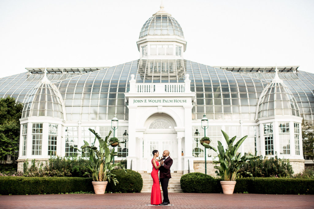 Couple wearing luxurious clothes in front of the John F. Wolfe Palm House in Columbus.
