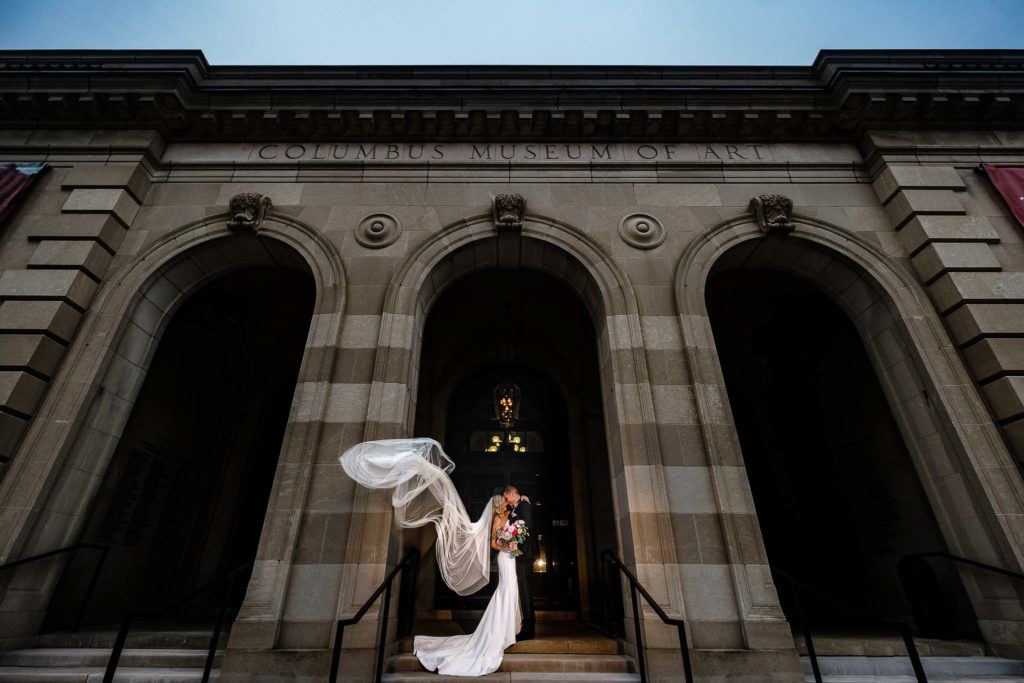 Bride and groom with veil outside of the Columbus Museum of Art.