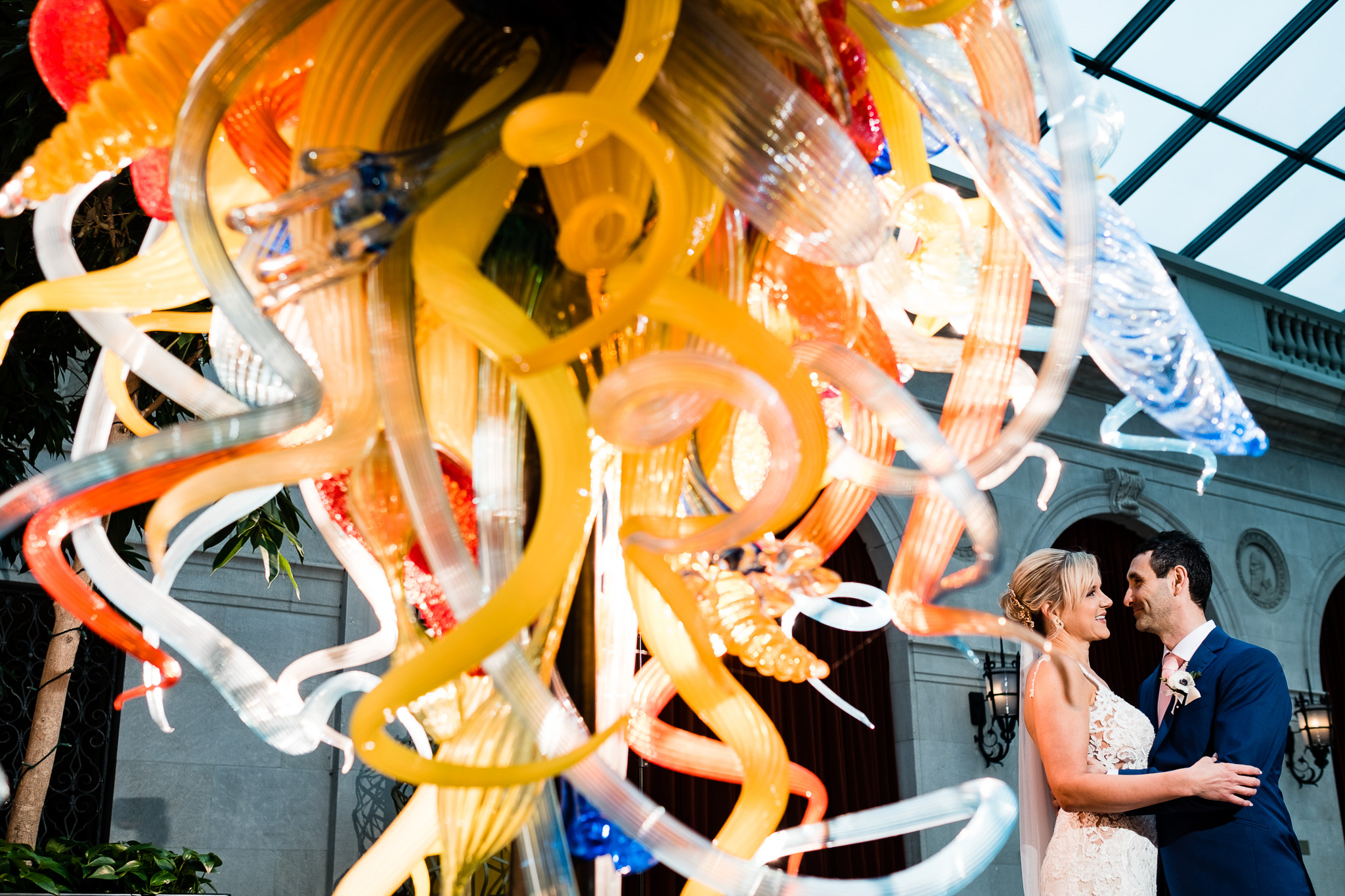 Couple getting married at the Columbus Museum of Art with world-renowned artist Dale Chihuly’s Isola di San Giacomo in Palude glass sculpture.