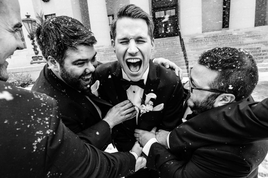 The groom and groomsmen laughing at the Ohio Statehouse