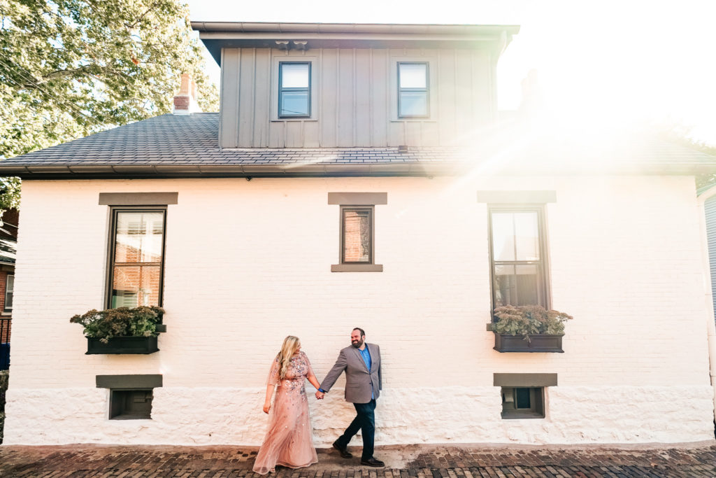 Couple walking and holding hands during their engagement session in German Village. Best Places to Propose in Columbus Ohio