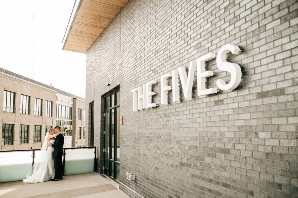 A newly married couple outside of the fives in columbus. 