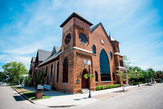 Brooklyn Art Center facade with a church type architecture with red brick and arched windows.