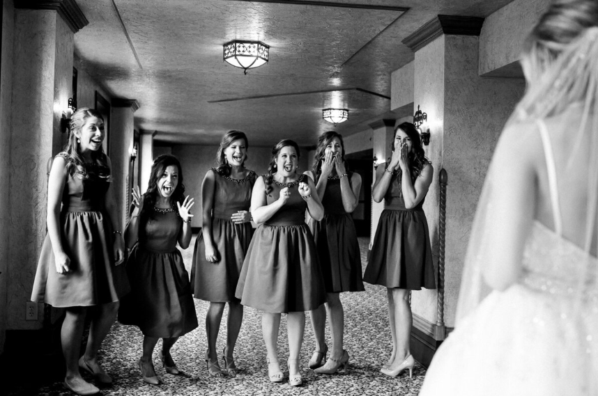 Storyteller Adams Bride Reveal in a Hotel Setting. The brides are celebrating the first look at the bride in the hallway.