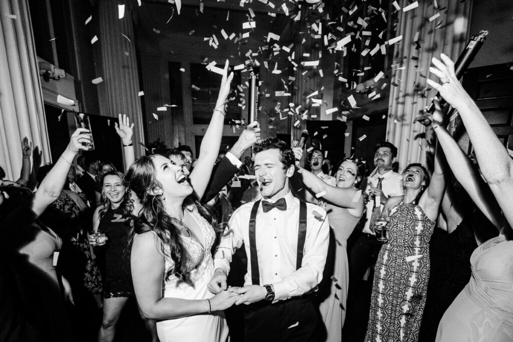 Storyteller Adams B&W Photo with couple at a wedding reception with confetti.