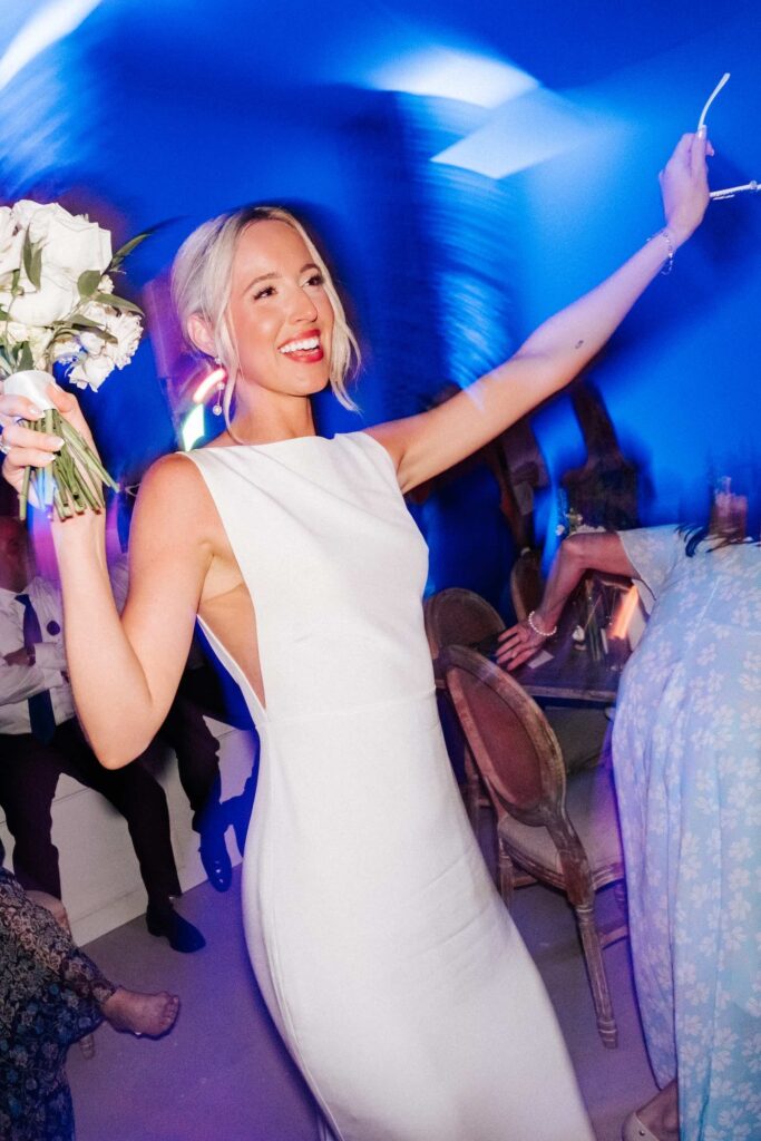 Bride dancing with bouquet during her wedding at the reception inside of the Wrightsville Manor.
